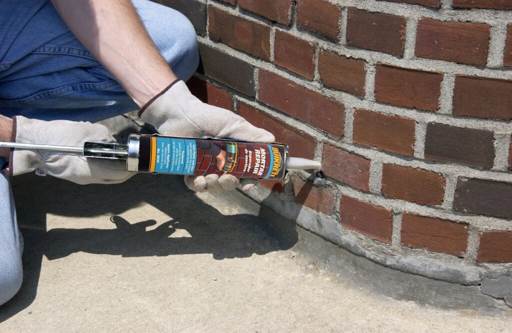 Professional brownstone masonry contractor preparing joints for mortar replacement
