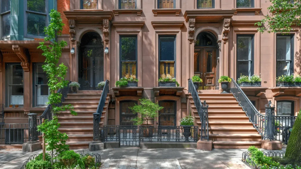 Renovated brownstone townhouse entrance with steps and classic brick façade.