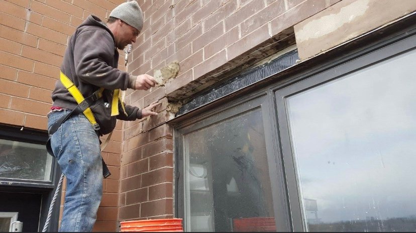 Contractor performing window lintel replacement and stone facade repair