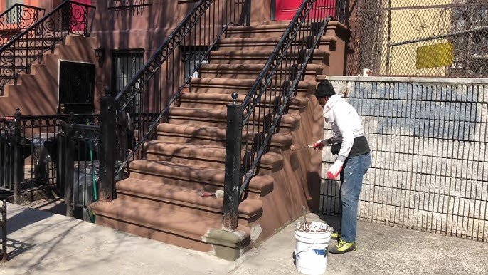 Brownstone stoop and steps repair service in New York City featuring iron railings