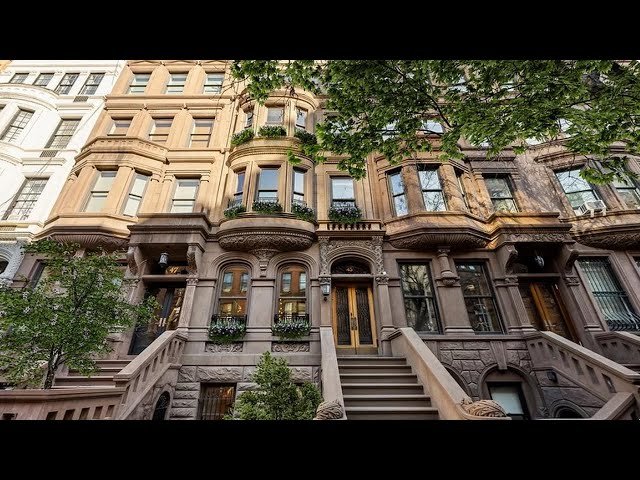 Historic brownstone building with front stoop and detailed architectural columns in New York City.