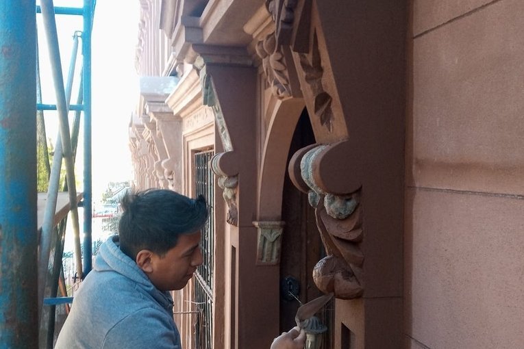 Mason restoring carved detail on a NYC brownstone facade